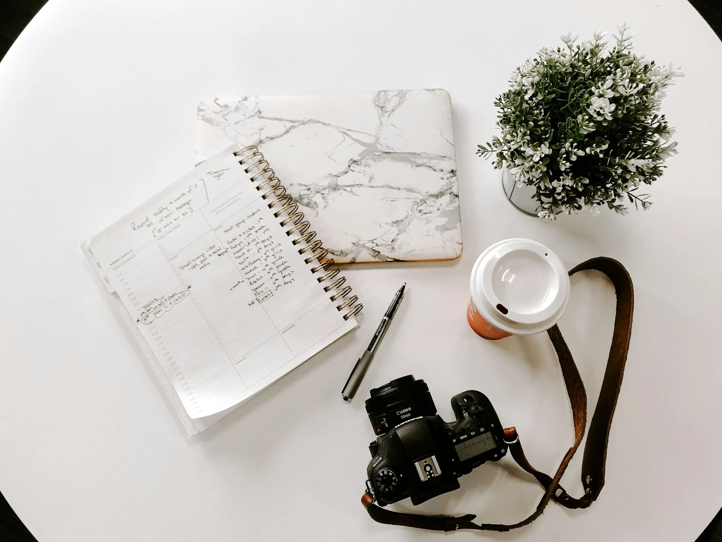 A travel notebook, pen, and passport on a desk