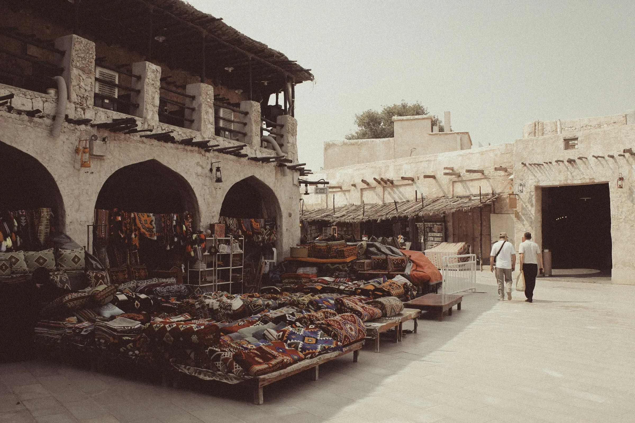 People walking through the covered market lanes of Souq Waqif